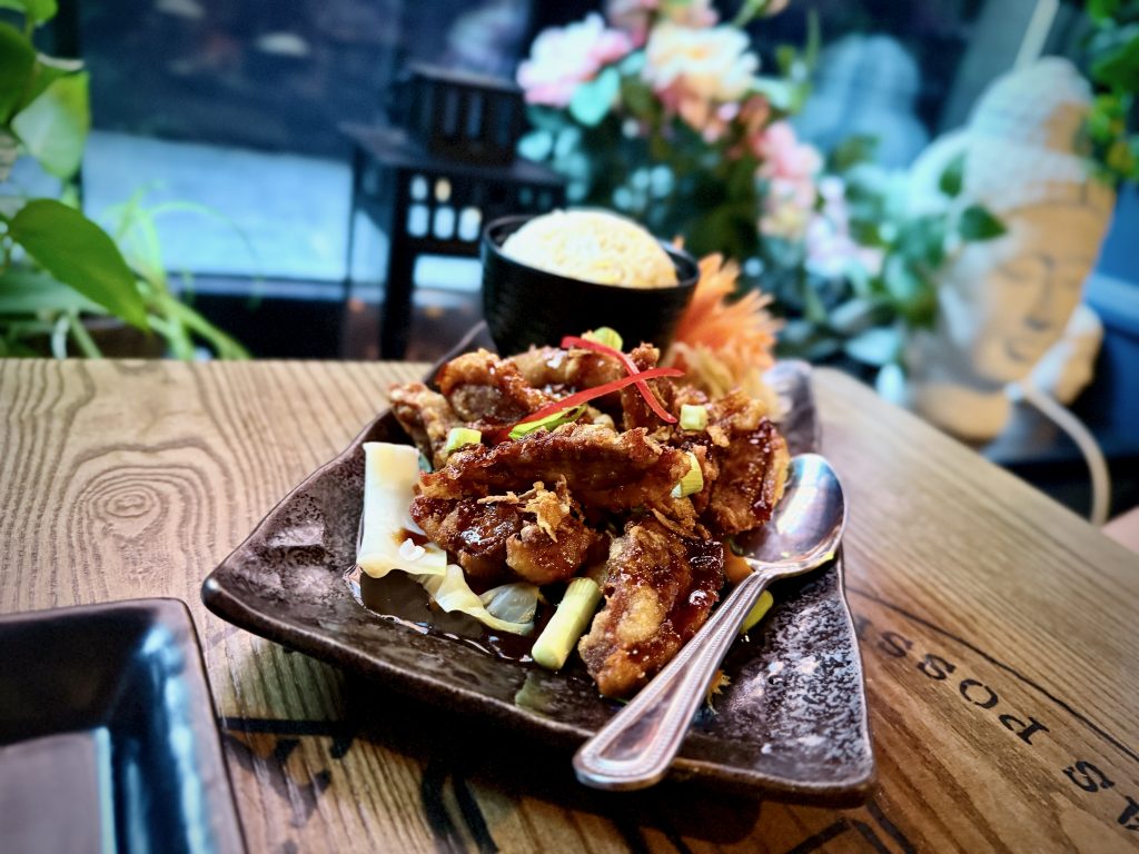 Crispy duck with tamarind sauce garnished with spring onions and chillies, served with rice at My Thai (Old Steps) in Leeds.