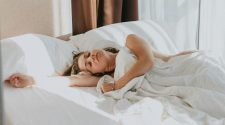 Lady sleeping in bed with white sheets